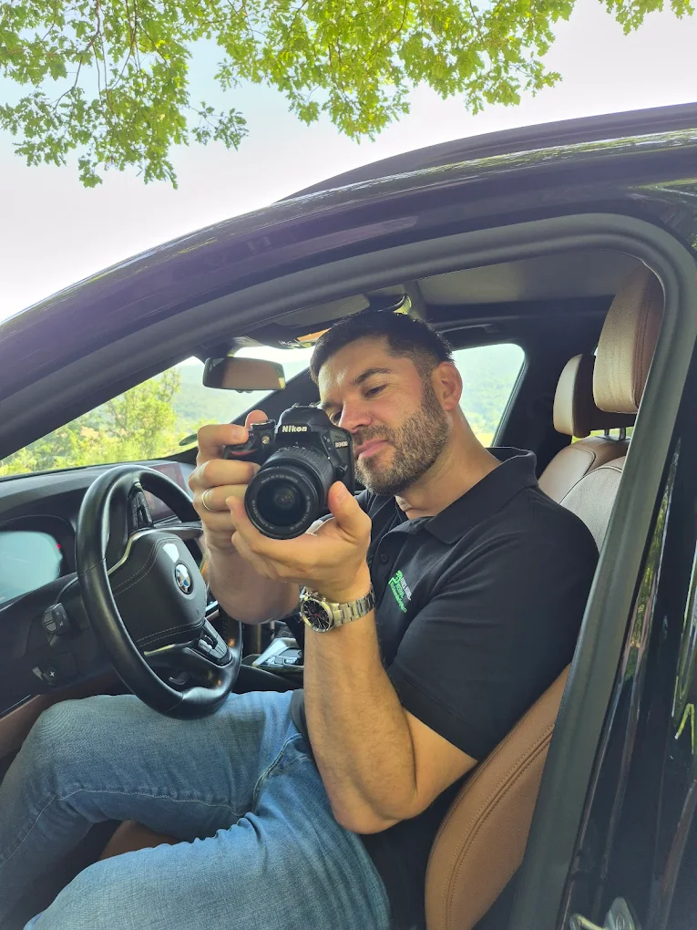 Patrick Kunkel, Kfz-Sachverständiger, bei der Fahrzeugbegutachtung mit Kamera