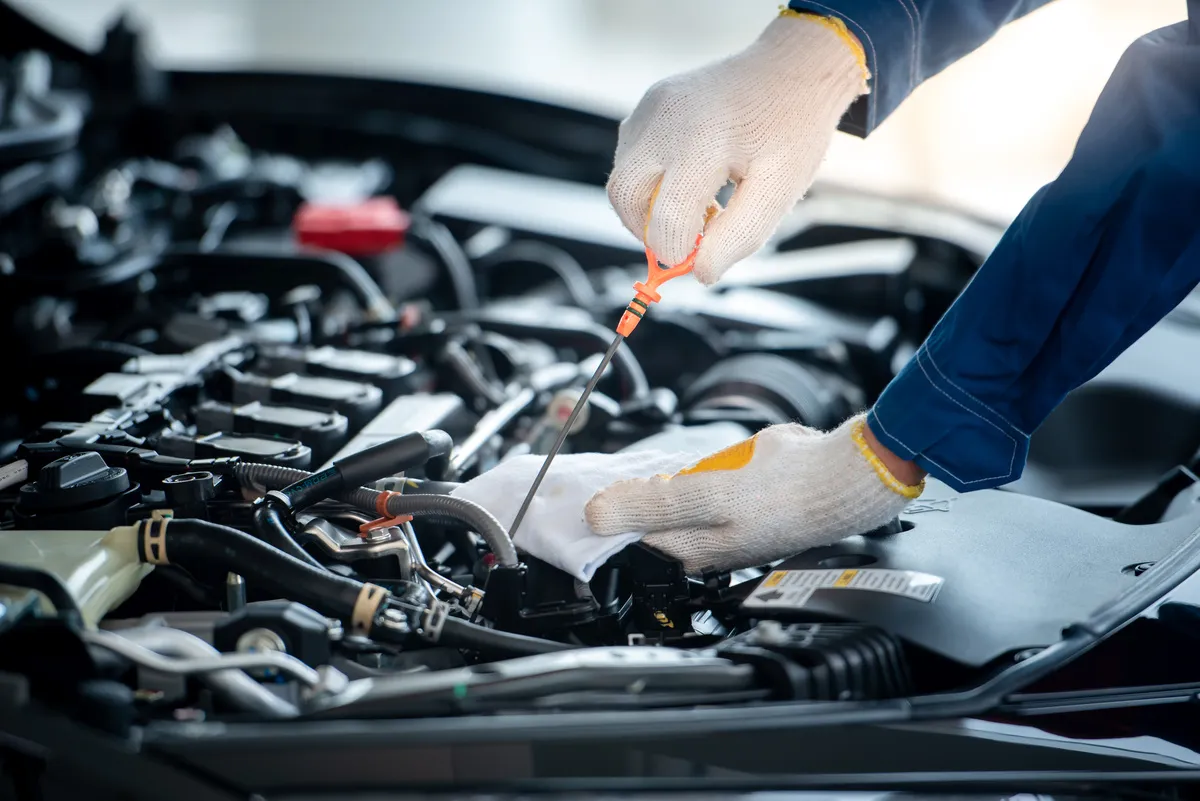 Kfz-Sachverständigenbüro Patrick Kunkel Wiesthal – Ein Mechaniker für asiatische Fahrzeuge überprüft in einer Autowerkstatt den Motor. 